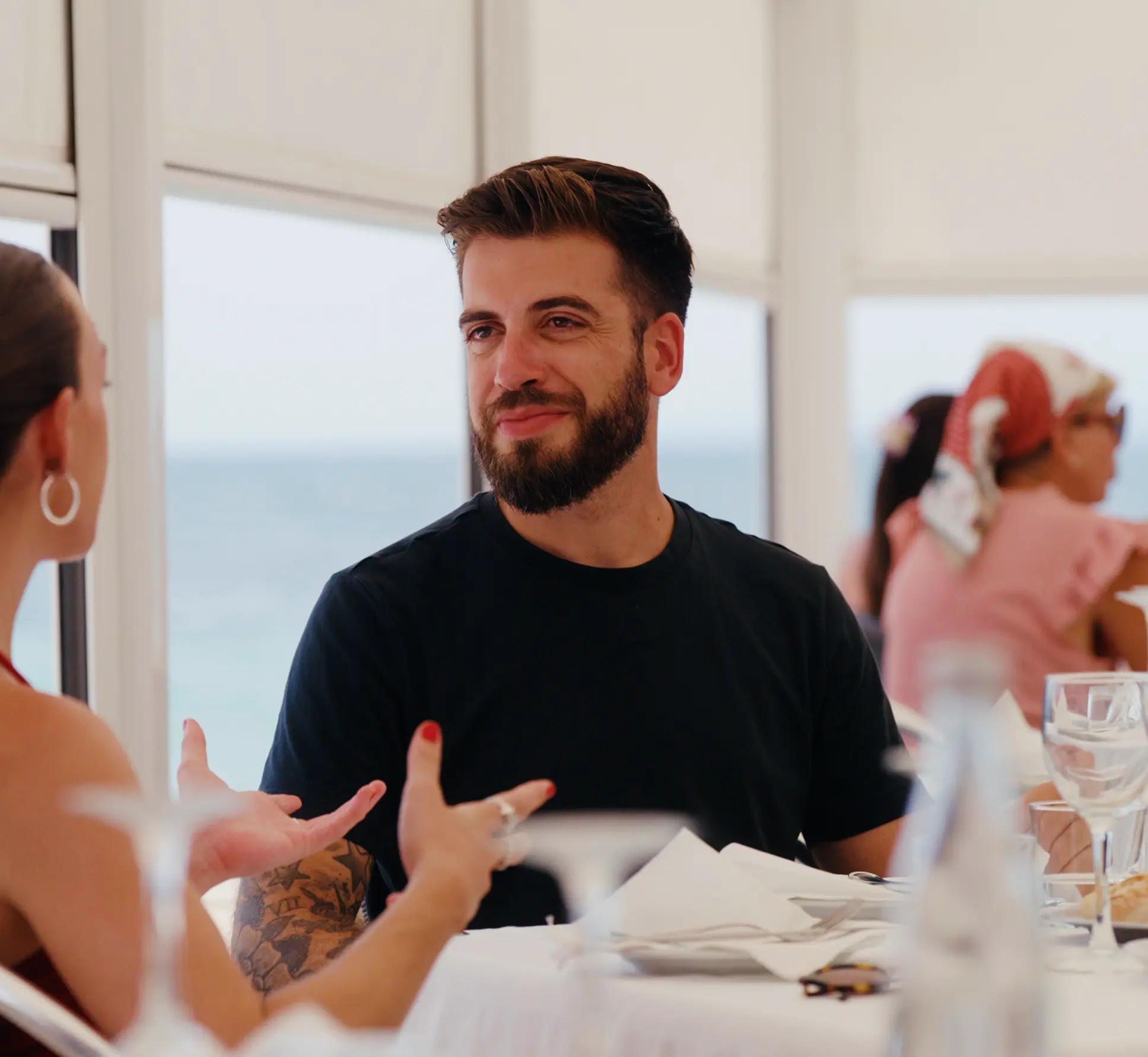 Aleix Brunsoms dining outdoors with a colleague overlooking the coast